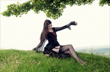 Goth girl exposes her natural tits in sexy lingerie and nylons out in a field 21121983