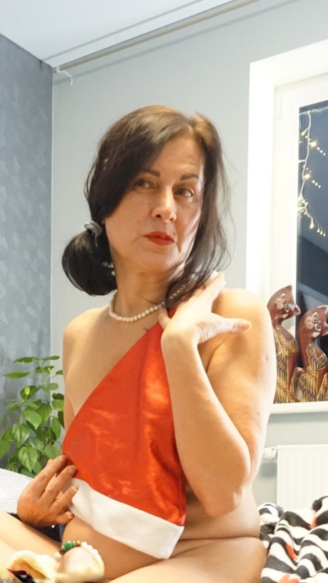 Older brunette Diana Ananta displays her hairless vagina while naked on a bed